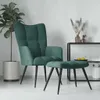 A dark green velvet armchair and ottoman are displayed in a minimalist room setting with a potted plant and a shelf with decorative items. Produktbild-Vorschau