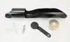 A collection of items, including a black metal object, a white funnel, a small metal bracket, a black circular tool, and a spool of white material, laid out on a white background. Produktbild-Vorschau