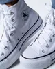 A close-up shot of two white Converse Chuck Taylor All Star high-top sneakers. Voir les images du produit