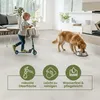 A child rides a scooter and a dog drinks from a bowl in a modern living room with floor tiles. Produktbild-Vorschau