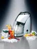An ice crusher machine with cocktails and ice scattered around it. Náhled obrázku produktu