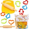 A baking set with a cutting board, rolling pin, and various shaped cookie cutters, some of which are in a plastic bag. Podgląd zdjęcia produktu