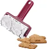 A cookie roller with a patterned cylinder is shown above several baked cookies. Produktbild-Vorschau