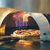 A pizza is being cooked in a wood-fired oven. Produktbild-Vorschau
