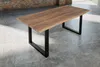 A wooden dining table with black metal legs on a concrete floor. Produktbild-Vorschau
