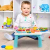 A baby is sitting on the floor playing with a colorful activity table. There are other toys in the background. Podgląd zdjęcia produktu