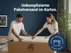 A couple is unboxing a rolled-up mattress from a large cardboard box. Produktbild-Vorschau
