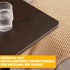 Close-up of a dark brown table edge with a glass of water and a textured blanket in the background. An orange overlay with German text is at the bottom. Anteprima dell’immagine prodotto