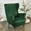 A green velvet wingback chair is shown in a room with a plant in the background. Anteprima dell’immagine prodotto