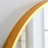 A close-up shot of the edge of a round mirror with a gold frame. Produktbild-Vorschau