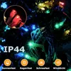 Close-up of colorful LED string lights in the dark, with icons and text indicating features. Produktbild-Vorschau