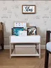 A child's bedroom with a wooden shelf unit filled with books and a decorative box. Podgląd zdjęcia produktu