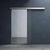 A modern glass sliding door installed in a room with dark gray walls and a concrete floor. Produktbild-Vorschau