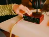 A person's hand is shown plugging a cable into a red audio interface device. Anteprima dell’immagine prodotto