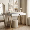 A white console table with an open drawer, a stool, and decorative items, set in a room with artwork and curtains. Produktbild-Vorschau
