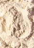 A close-up view of a footprint pressed into a pile of light-colored powder, likely flour or protein powder. Produktbild-Vorschau