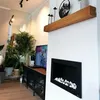 A modern living room with a fireplace, TV, and plants. Náhled obrázku produktu