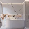 A modern bathroom with a white bathtub, marble walls, and decorative elements. Produktbild-Vorschau