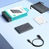 A flat lay of a product box, power bank, charging cable, user manual, and a storage pouch on a blue and gray background. Produktbild-Vorschau