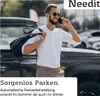 A man is standing next to a car, talking on his phone and carrying a bag over his shoulder. Produktbild-Vorschau