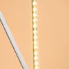 A close-up shot of a string of LED lights against a light orange background. Produktbild-Vorschau