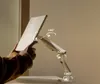 A person's hand is adjusting a monitor stand with a tablet attached. Produktbild-Vorschau