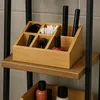 A bamboo organizer filled with makeup and hair accessories sits on a shelf. Náhled obrázku produktu
