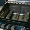 Close-up view of the interior of a grill, showing the burner and heat deflectors. Voir les images du produit