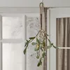 A decorative mistletoe branch with LED lights hangs from a hook. Produktbild-Vorschau