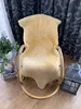 A sheepskin rug draped over a rocking chair, with curtains and decorative items in the background. Produktbild-Vorschau