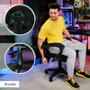 A man is sitting in a gaming chair in a room with gaming equipment in the background. Produktbild-Vorschau