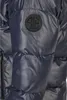 Close-up of a dark blue quilted jacket sleeve with a circular black logo. Voir les images du produit
