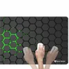 A hand is shown using a white computer mouse on a black and green hexagonal patterned mousepad. Náhled obrázku produktu
