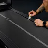 A person is applying lubricant to a treadmill belt. Produktbild-Vorschau