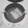 Top-down view of an open air fryer with a mesh basket inside containing a folded instruction manual. Produktbild-Vorschau