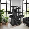 A large, multi-level cat tree with various platforms, perches, and scratching posts, placed in a well-lit room with large windows and indoor plants. Náhled obrázku produktu