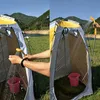 Two side-by-side images showing a portable camping shower tent being used outdoors near a body of water and hills. One image shows hands washing with the shower head, and the other shows the shower head spraying water inside the tent. Voir les images du produit