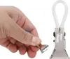 A hand is holding a metal clip with a clear loop attached. Anteprima dell’immagine prodotto