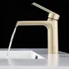 A modern gold faucet with water flowing into a white sink against a black background. Anteprima dell’immagine prodotto