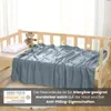 A gray fleece blanket is draped over a child's bed, with a teddy bear and pillow on the bed. Produktbild-Vorschau