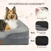 A dog is lying on a gray orthopedic dog bed, with diagrams illustrating features of the bed. Produktbild-Vorschau