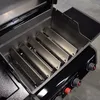 Close-up view of the inside of a grill, showing the burner covers. Podgląd zdjęcia produktu