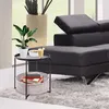 A round black side table with a storage basket and a plant, bowl of cereal, and drink on top, placed next to a black leather sofa. Produktbild-Vorschau