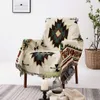 A boho-style blanket draped over an armchair in a living room setting. Produktbild-Vorschau