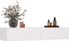 A white floating shelf with decorative items on top, including a vase of flowers and bottles. Produktbild-Vorschau