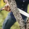 A person is using a hand saw to cut a tree branch. Produktbild-Vorschau