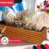 A person is planting flowers in a wooden planter box. Náhľad obrázku produktu