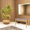 A shoe rack with a bench and a potted plant in a room with wood-paneled walls. Produktbild-Vorschau