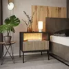A modern bedroom setting with a nightstand, bed, and decorative elements. Produktbild-Vorschau