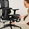 A woman is adjusting an office chair. Produktbild-Vorschau